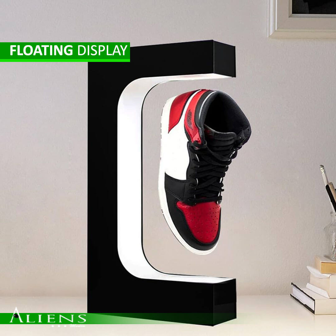 Magnetic floating display showcasing various products like shoes, watches, and mobiles.