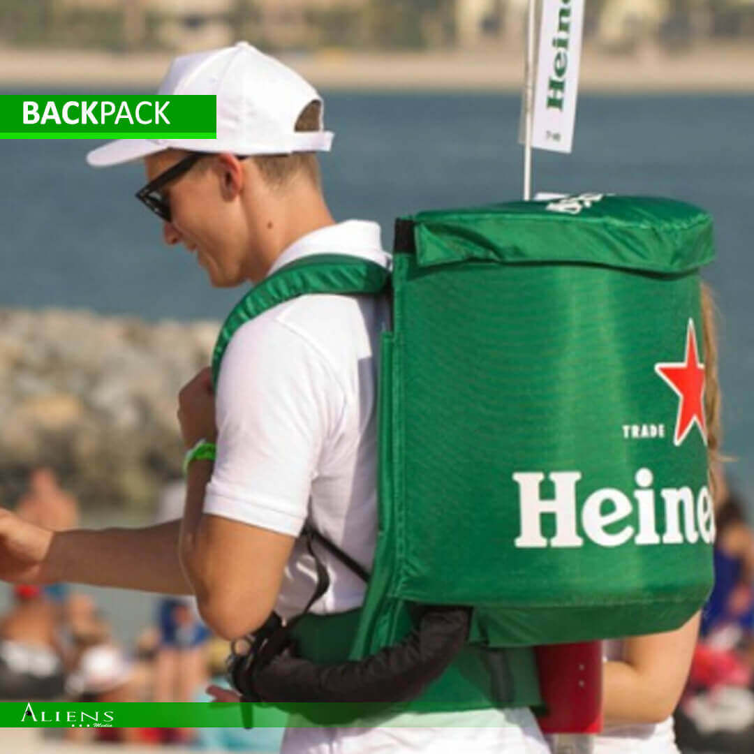 Eco-friendly backpack dispenser with custom branding at a public festival.