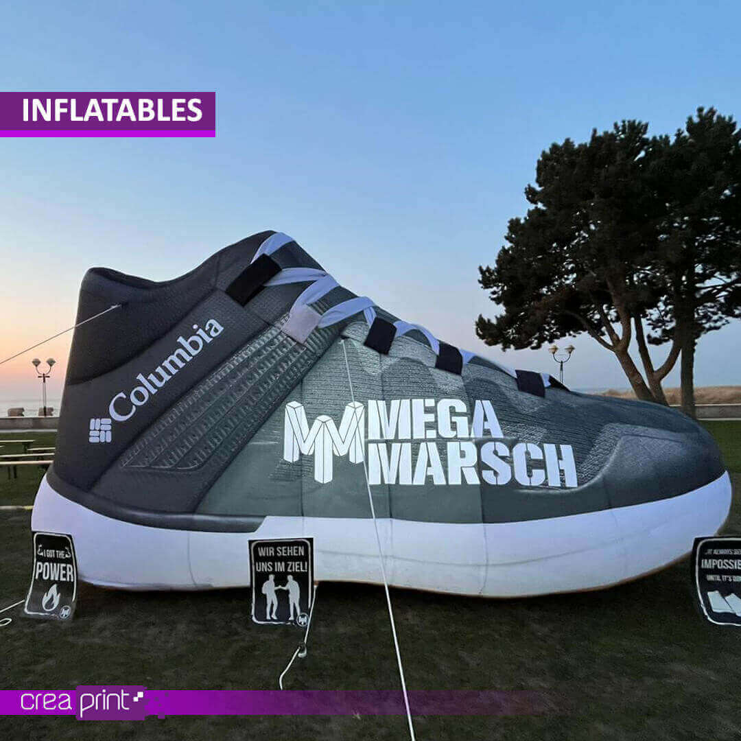 A vibrant image of a giant inflatable shoe replica at a promotional event, attracting attention and generating excitement among attendees. People are taking photos with the inflatable shoe.